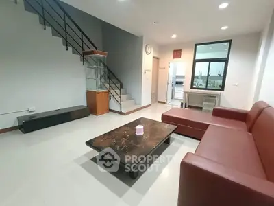 Spacious modern living room with sleek staircase and open kitchen view