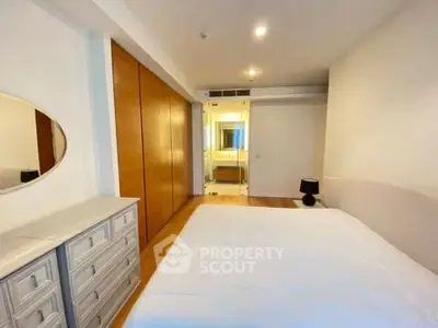Spacious bedroom with modern design and ample storage in a luxury apartment.