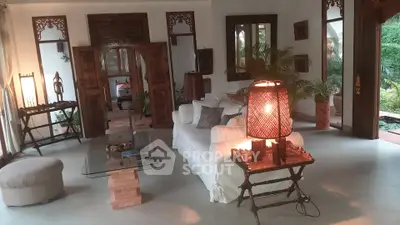 Elegant living room with rustic wooden decor and cozy lighting, featuring a plush white sofa and glass coffee table.