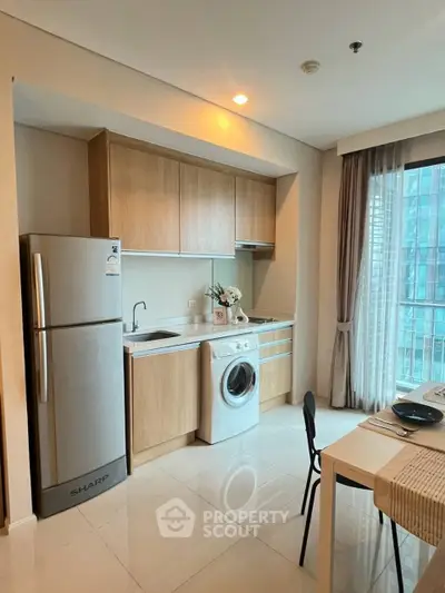 Modern kitchen with sleek appliances and natural light in a stylish apartment.