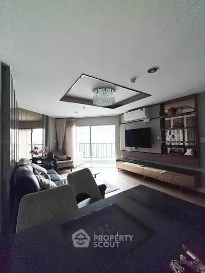 Spacious living room with modern decor and balcony access in luxury apartment.