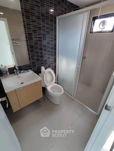 Modern bathroom with sleek design, featuring a glass shower enclosure and stylish vanity.