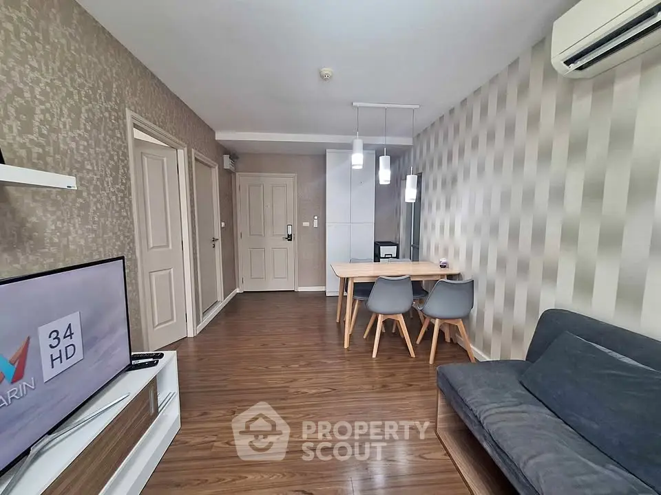 Modern living room with stylish decor, wooden flooring, and cozy seating area.