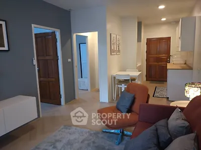 Modern living room with stylish furniture and open kitchen layout in cozy apartment.