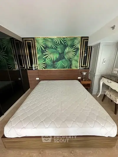Stylish bedroom with modern decor and tropical accent wall, perfect for relaxation and comfort.