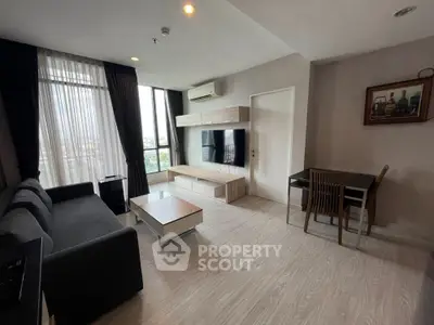 Modern living room with sleek furniture and large windows offering city views