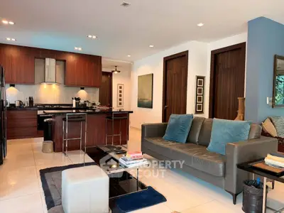 Spacious modern living room with open kitchen, sleek furniture, and elegant decor in a luxurious apartment.