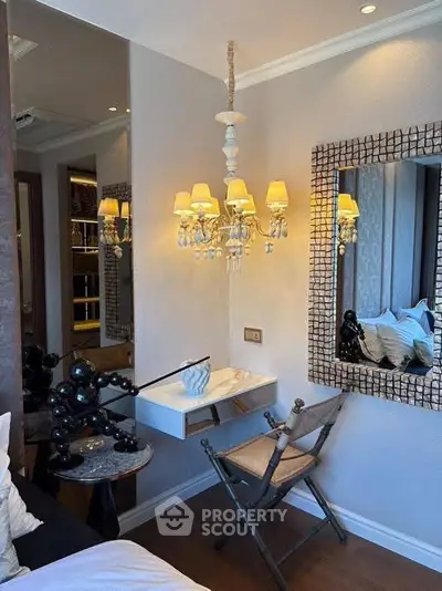 Elegant bedroom corner with chandelier and mirror, perfect for cozy relaxation.