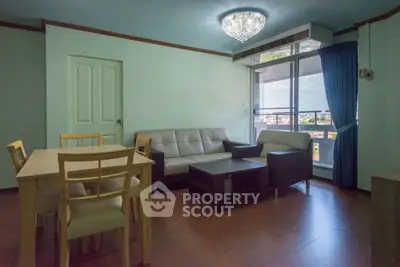Spacious living room with modern furniture and large window offering city views.