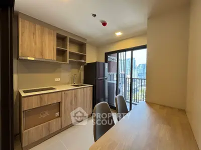 Modern kitchen with open layout and city view from balcony, featuring sleek wooden cabinetry and dining area.