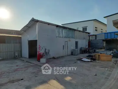 Industrial warehouse exterior with spacious yard and potential for development.