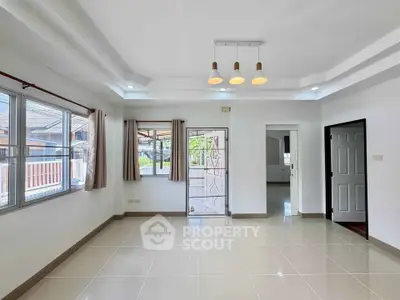 Spacious and bright living room with modern lighting and large windows in a contemporary home.