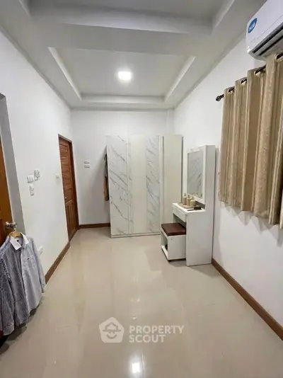 Spacious bedroom with modern wardrobe and air conditioning, ideal for comfort and style.