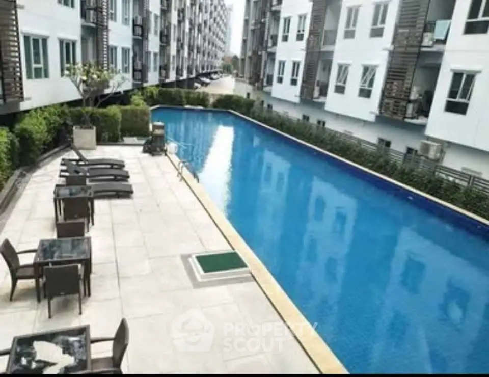 Modern apartment complex with a spacious outdoor swimming pool and lounging area.