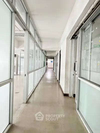 Spacious corridor with glass partitions in modern building