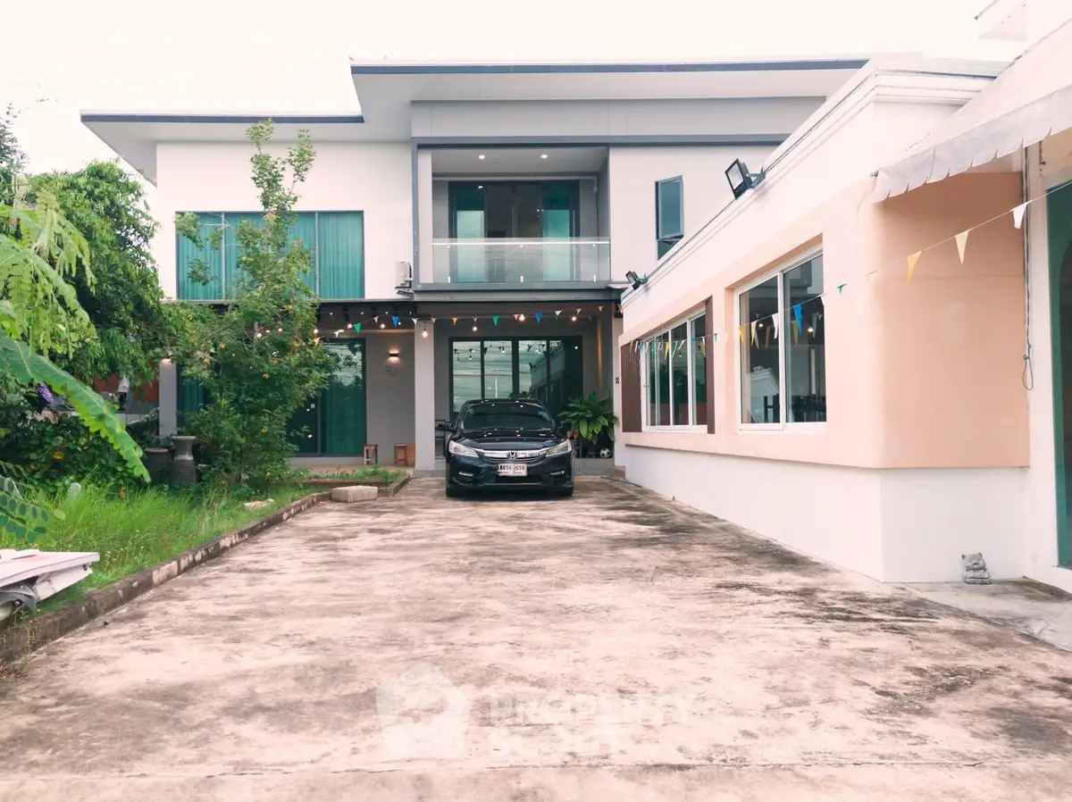 Modern two-story house with spacious driveway and sleek exterior design.