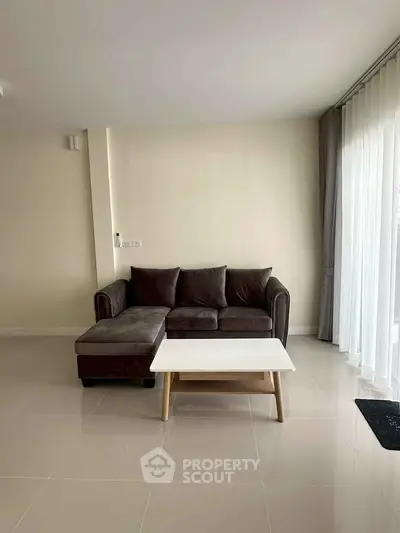 Modern living room with sleek sofa and coffee table, featuring minimalist design and natural light.