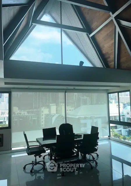 Stunning office space with high ceilings and panoramic city views, perfect for a modern workspace.