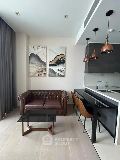 Modern living room with leather sofa, stylish kitchen bar, and contemporary art decor.