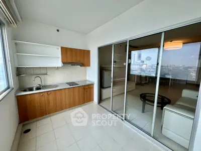 Modern kitchen with open layout and sliding glass doors leading to a bright living room.