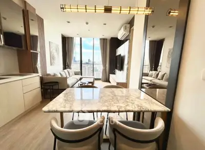 Modern living room with city view, featuring elegant marble dining table and stylish decor.