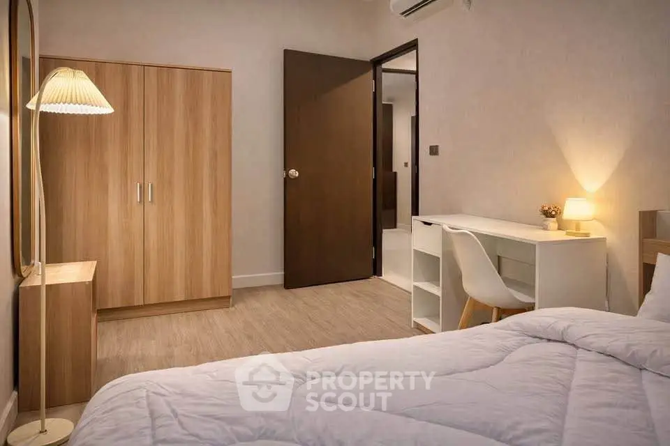 Cozy bedroom with modern furniture, featuring a wooden wardrobe, desk, and comfortable bed.