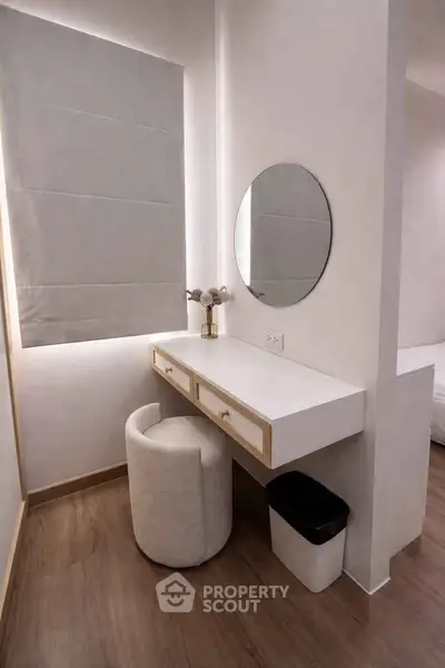 Modern minimalist bedroom corner with vanity and round mirror