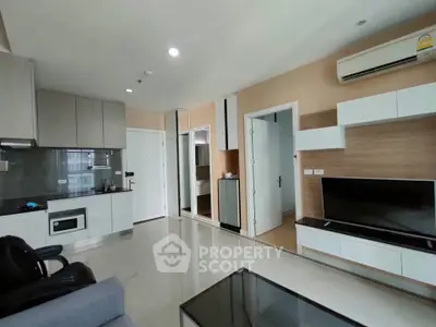Modern living room with sleek kitchen and stylish decor in contemporary apartment.