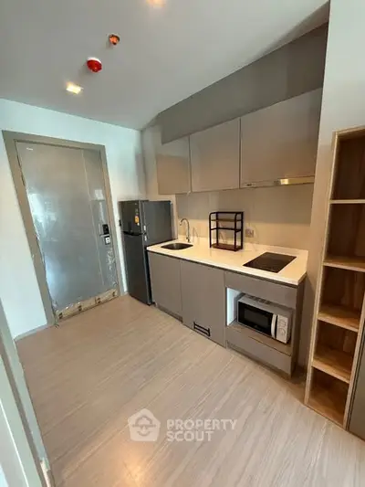 Modern kitchen with sleek cabinets and built-in appliances in a compact layout.