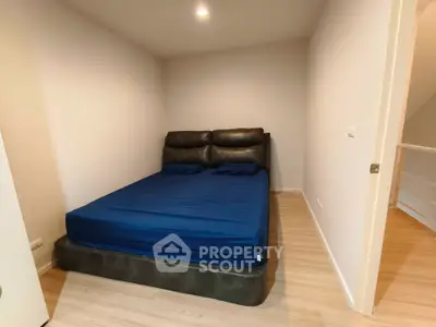 Cozy bedroom with modern bed and wooden flooring, perfect for relaxation.