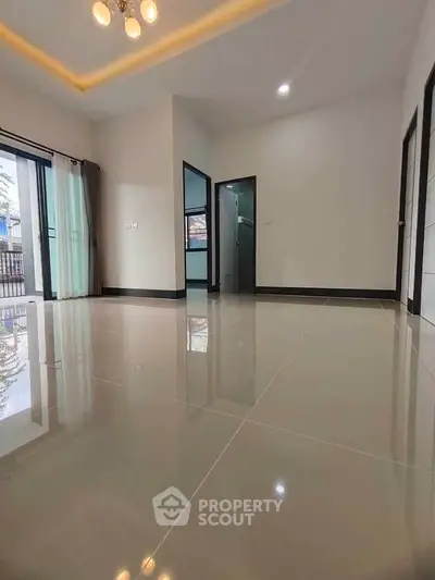 Spacious modern living room with glossy tile flooring and large windows for natural light.