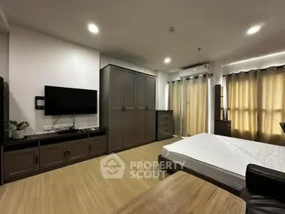Spacious modern bedroom with sleek furniture and natural light, perfect for comfortable living.