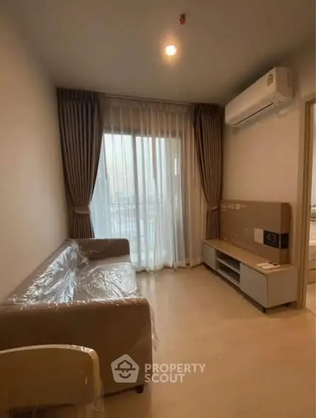 Cozy living room with modern sofa and air conditioning, perfect for relaxation.