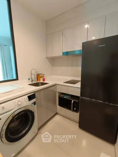 Modern kitchen with sleek appliances and ample storage in a stylish apartment.