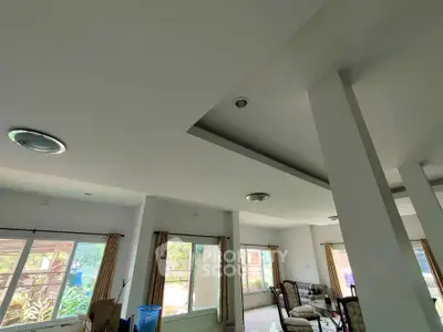 Spacious living room with large windows and modern ceiling design