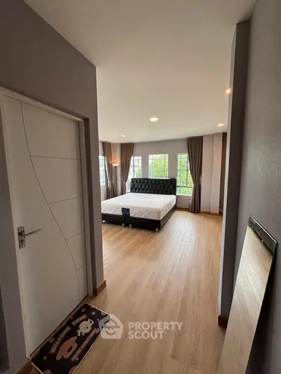 Spacious bedroom with modern decor and large windows for natural light