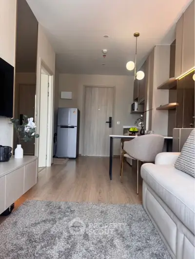 Modern living room with open kitchen, stylish decor, and cozy seating area.