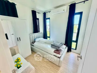 Bright and cozy bedroom with modern furnishings and large windows for natural light.