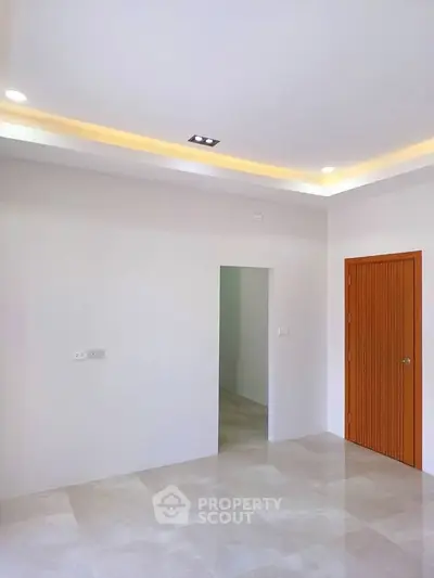 Spacious modern interior with recessed lighting and sleek tile flooring, perfect for customization.