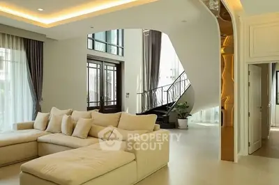 Luxurious living room with elegant staircase and plush sofa in modern home