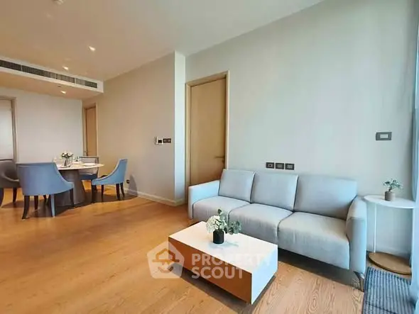 Modern living room with elegant dining area, featuring sleek furniture and stylish decor.