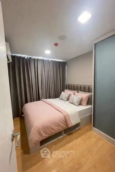 Cozy bedroom with modern decor and ample natural light, featuring a comfortable bed and stylish curtains.