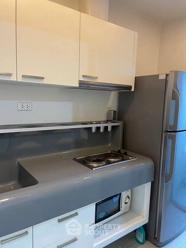 Modern kitchen with sleek cabinets and stainless steel fridge in a contemporary apartment.
