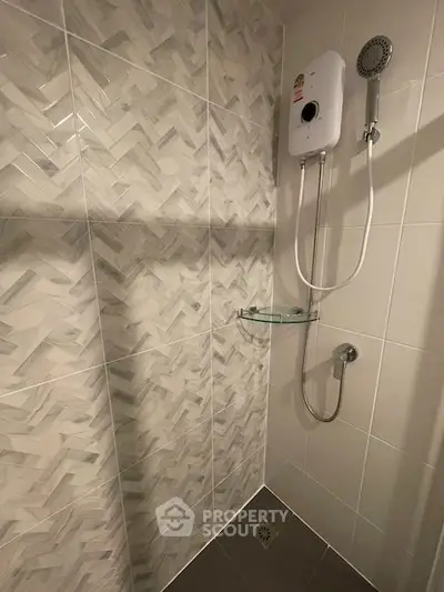 Modern bathroom with stylish tile design and wall-mounted shower unit.