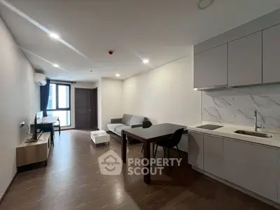 Modern open-plan living room with sleek kitchen and cozy seating area.