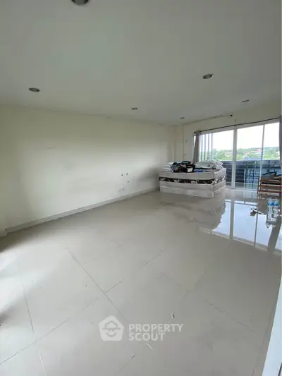 Spacious unfurnished room with large windows and balcony access, offering potential for customization.
