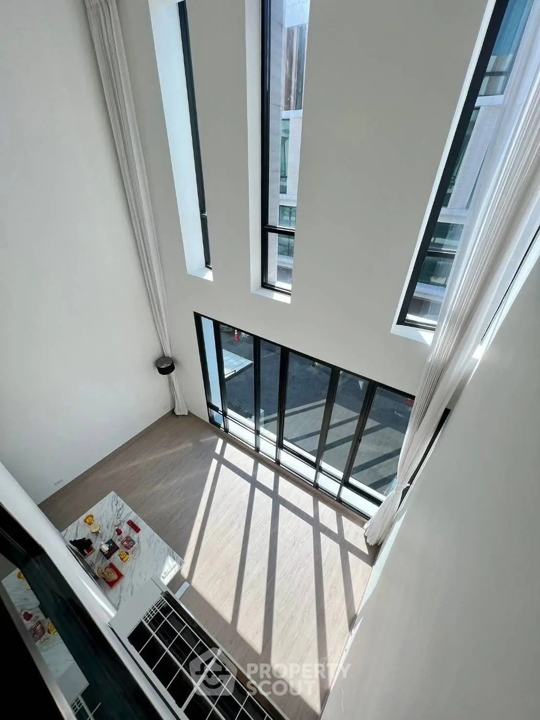 Stunning high-ceiling living room with floor-to-ceiling windows and abundant natural light.