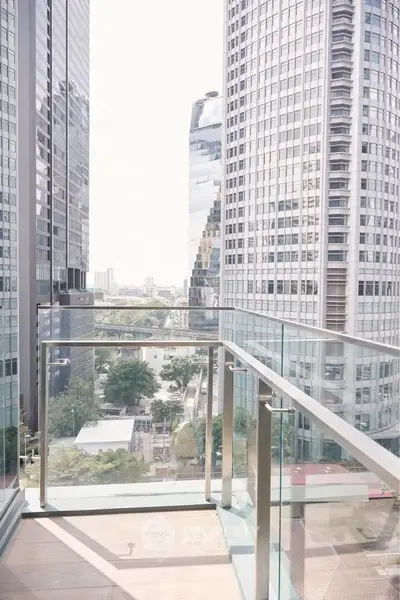 Stunning cityscape view from a modern glass balcony in a high-rise building.