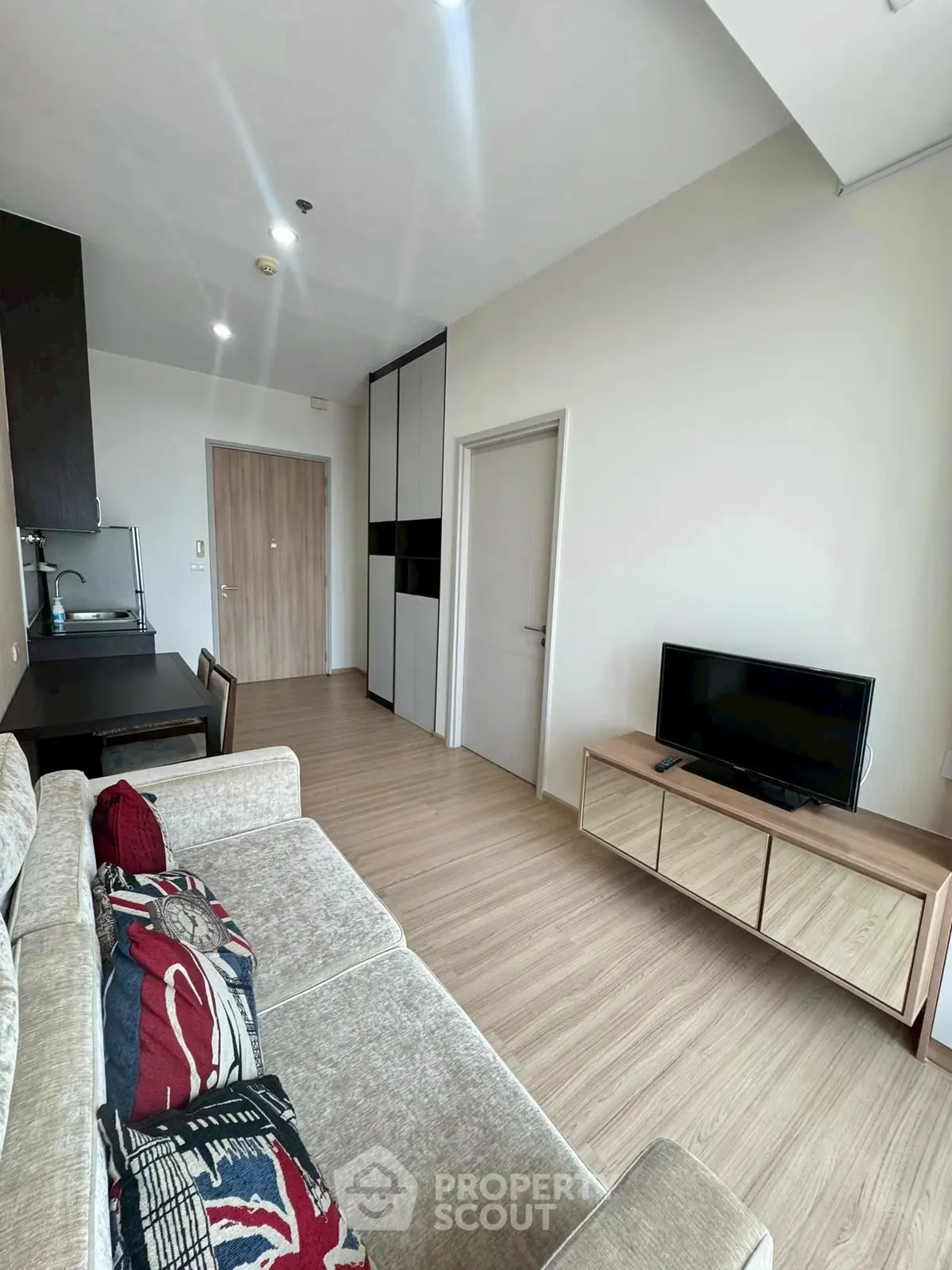 Modern living room with stylish furniture and open layout, featuring a cozy sofa and sleek TV stand.