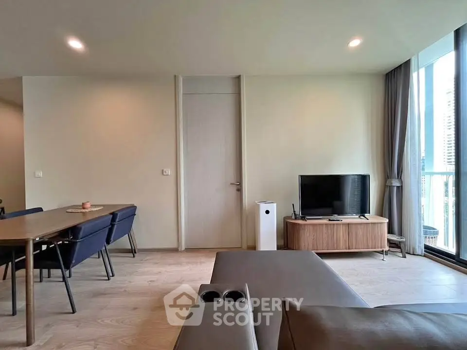 Modern living room with sleek furniture and large windows offering natural light.